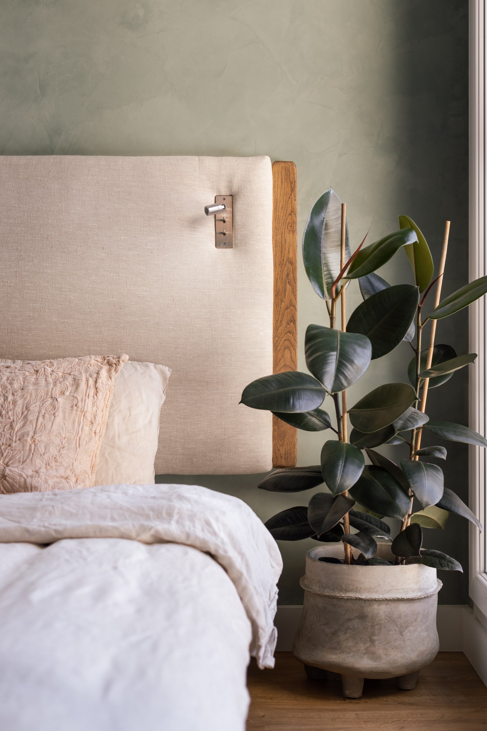 Détail de la chambre, tête de lit en lin et ficus, appartement rénové à Saint-Ouen