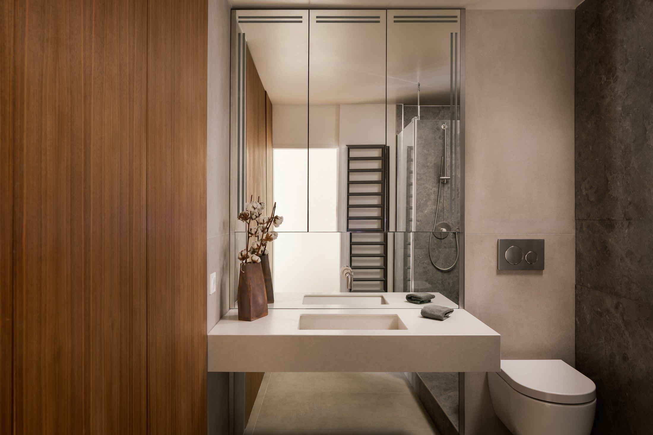 Salle de bain en pierre claire, double vasque et grand miroir, appartement à Saint-Ouen